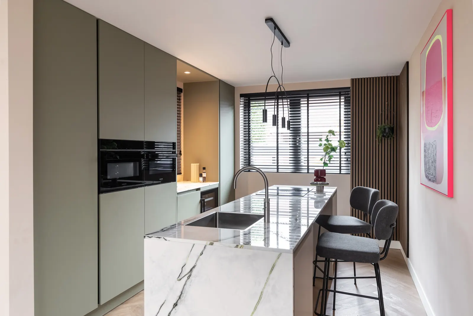 Open keuken met groene maatwerk kastenwand in een villa in Zwolle