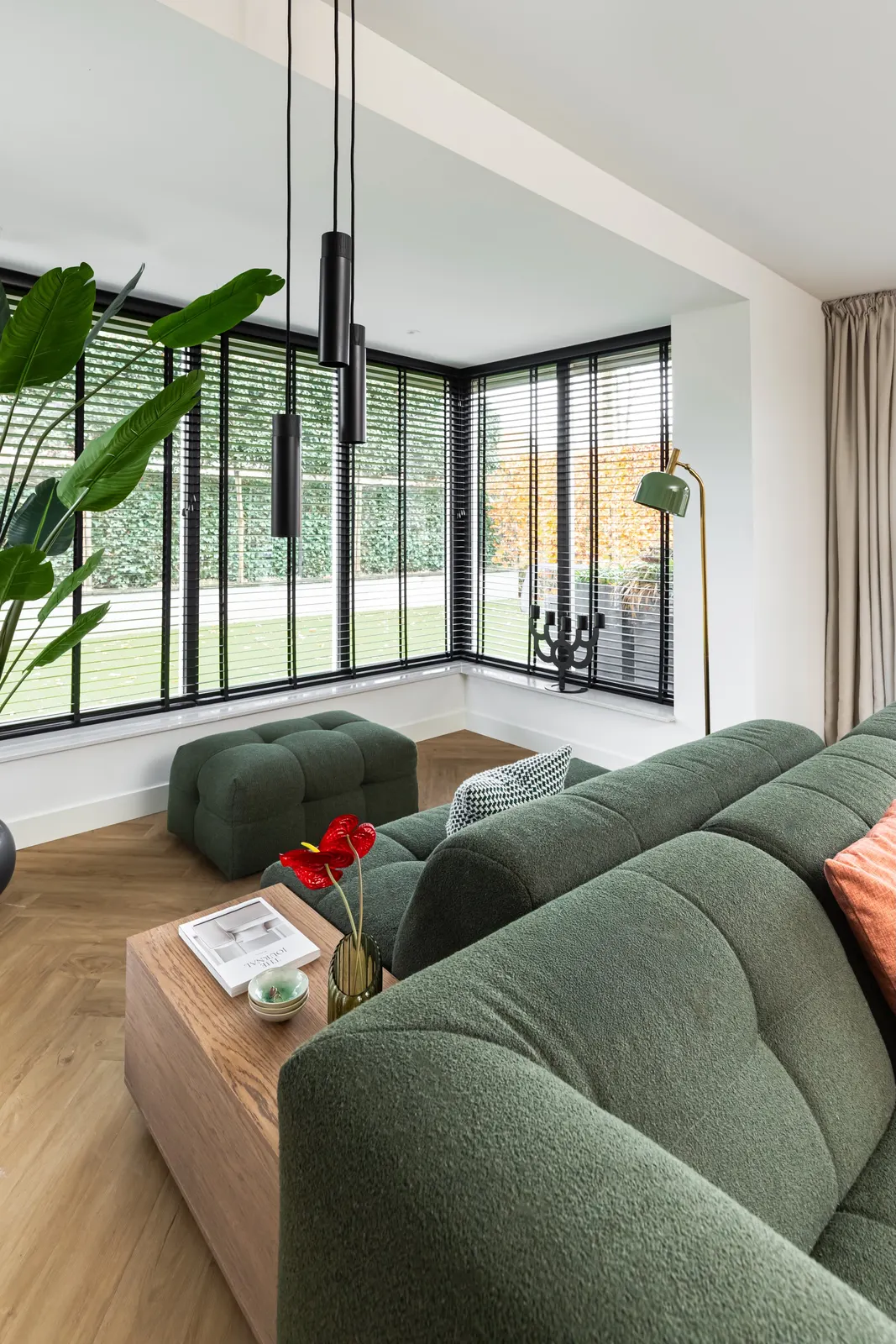 Woonkamer met groene modulaire bank bij de erker in een vrijstaande villa in Zwolle